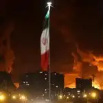 bendera iran berkibar saat api dan asap dari serangan israel terhadap depot minyak sharan membubung menyusul serangan israel t 1749980176957 169