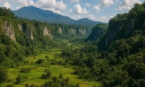 Panorama Ngarai Sianok, pemandangan alam dramatis dengan tebing curam, hutan tropis, dan sungai kecil yang mengalir melintasi dataran rendah.